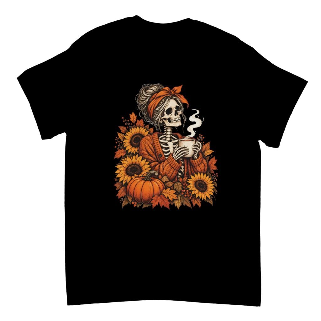 Skeleton Coffee Shirt in black with a skeleton in an orange cardigan and headband holding a steaming mug among sunflowers, a pumpkin and autumn leaves