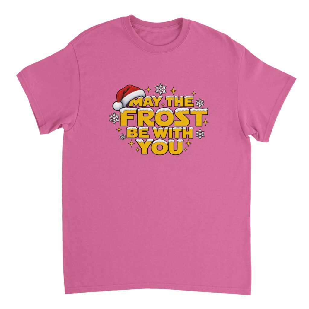 May the Frost Be With You Shirt in azalea pink with yellow gold snow-capped lettering, a red Santa hat, white snowflakes and gold sparkles
